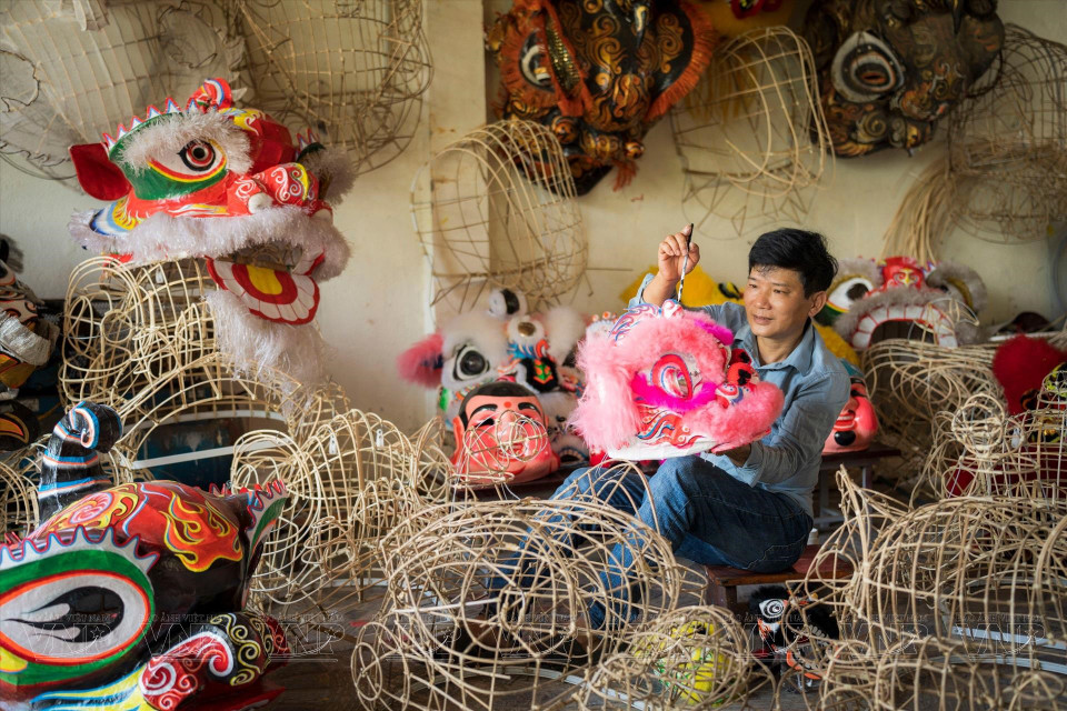 A local artisan makes lion heads (Photo: VNP/VNA)