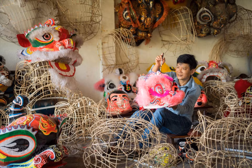 A local artisan makes lion heads (Photo: VNP/VNA)