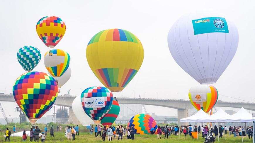 From early this morning, thousands of tourists flocked to Long Bien longan garden along the Red River to take pictures with the colourful hot air balloons. (Photo: VNA)