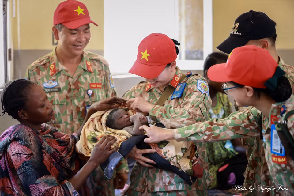 Female nurses and doctors from the Vietnam field hospital visit and give gifts to the Obstetrics Department at Bentiu General Hospital. Soldier Le Na is holding a newborn baby. (Photo provided by the field hospital)