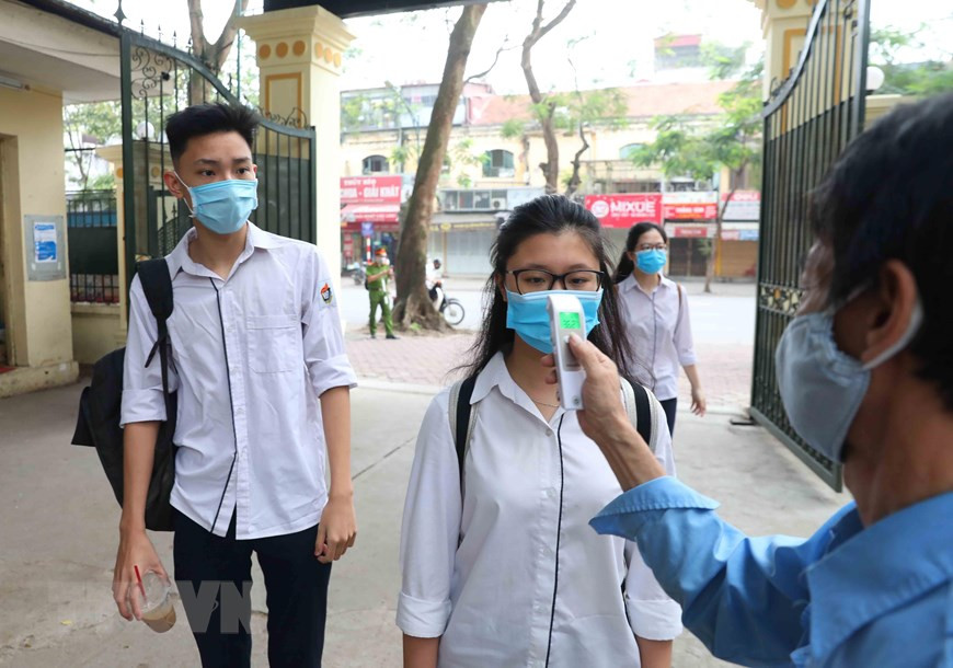 Students from Viet Duc high school are under temperature measurement before entering the school (Photo: VNA)