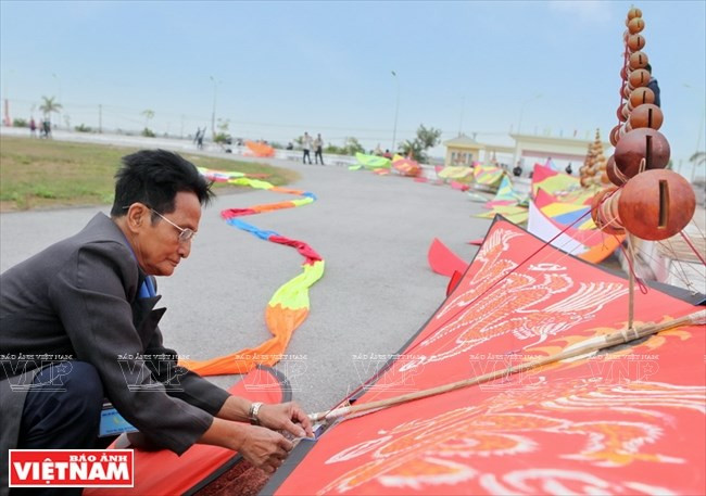 An old man is preparing his flute kite in a stadium in Thanh Oai district. (Source: VNA)