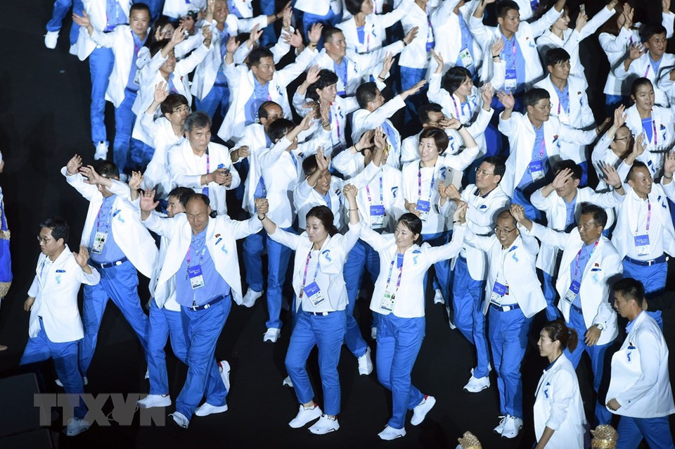 There were huge cheers when the Republic of Korea and the Democratic People’s Republic of Korea, whose athletes together number about 1,000, marched in together wearing pristine white and blue uniforms. (Photo: Xinhua/VNA)