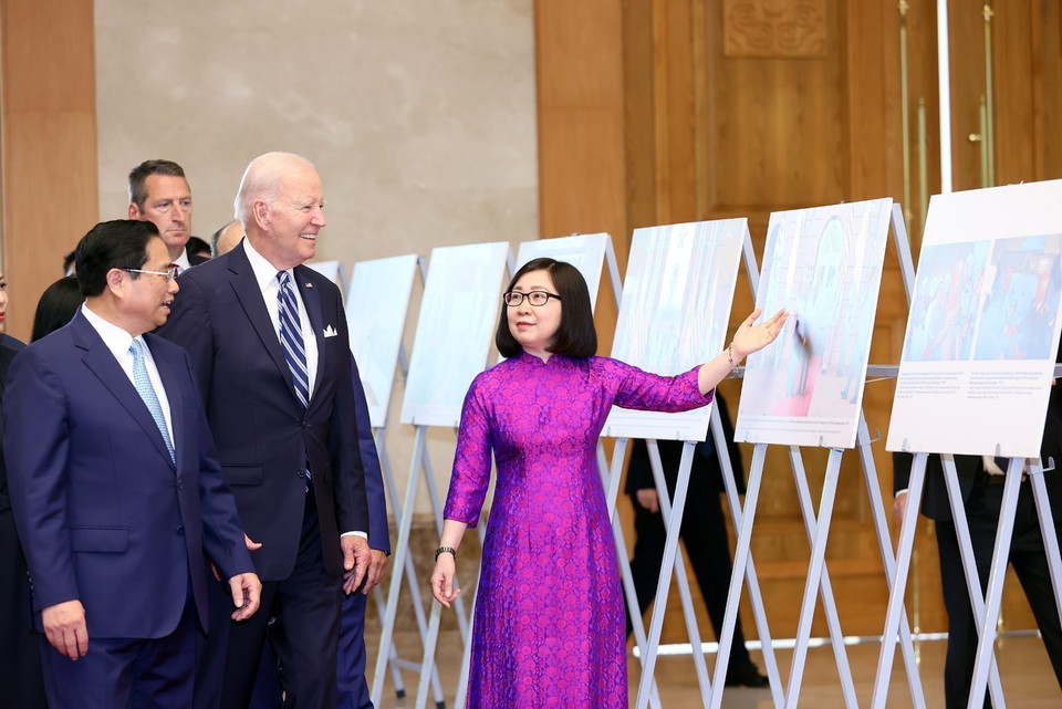 VNA Deputy Director General Doan Thi Tuyet Nhung presents photos on the Vietnam-US cooperation to Prime Minister Pham Minh Chinh and US President Joe Biden. (Photo: VNA)