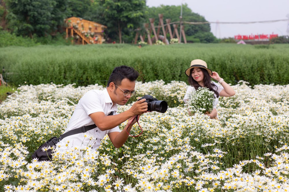 Each person has their own way of posing as they want to capture beautiful moments with the flowers, which are only in full bloom once a year. (Photo: Minh Son/Vietnam+)