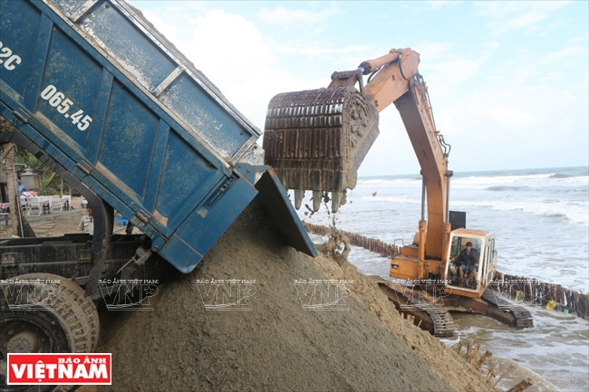 Cranes and trucks are used to make sand dams. (Source: VNA) 