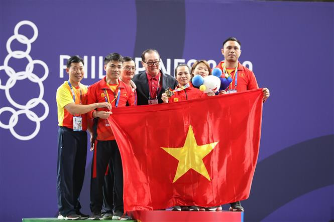 Vuong Thi Huyen receives a gold medal in the women’s weightlifting (Photo: VNA)