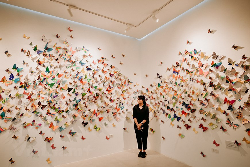 A spectator poses for photos at the exhibition (Photo: Vietnam+)