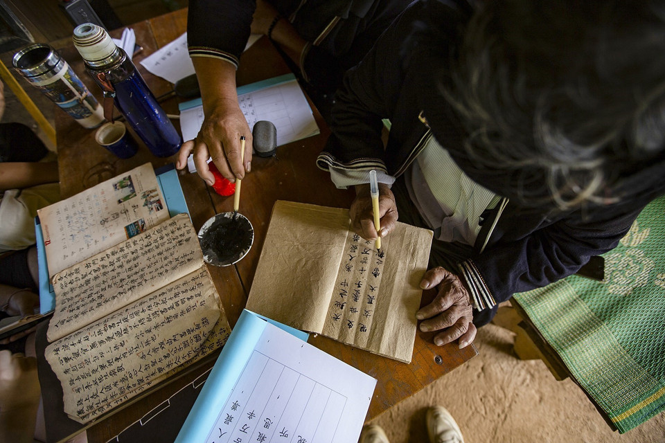 In his free time, Mr. Henh diligently writes and compiles letters in the Dao Tien ethnic group language. (Photo: VNA)