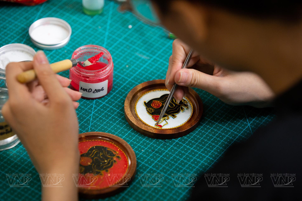 Once copper wire has been fashioned into a specific pattern or frame, the artisan proceeds to apply sand in various colours on the surface. (Photo: VNP/VNA)