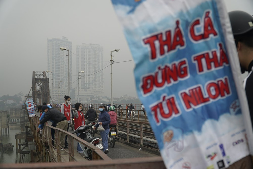 At Long Bien bridge, many volunteers help local people release carps safely. As the gods make their journey on the back of fish, traditions dictate the release of live carps into lakes or rivers, which is considered a kind-hearted deed to pray for good luck. Vietnamese people attach significance to this year-end departure by tidying the kitchen and making offerings on a specially designed alter. On that day, people also burn paper clothing, including hats, robes and boots, intended for use by the genies on the trip beyond. The Kitchen Gods day is one of the most sacred and meaningful annual events that officially starts the traditional Tet. (Photo: VietnamPlus)