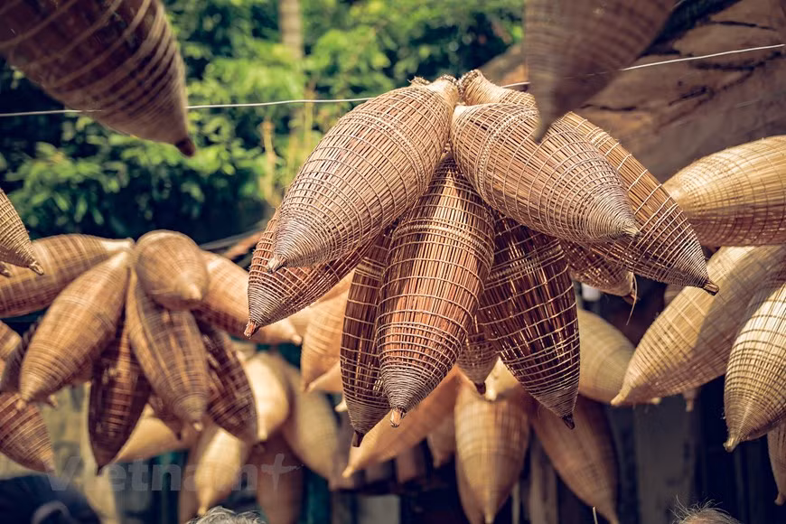 Fish pots are made from old bamboo, which is split and whittled by hand into even, thin strips of different sizes. Weaving fish pots requires patience and a love of the craft. Finished products are placed on a smoking shelf and smoked to enhance their durability. (Photo: Vietnam+)