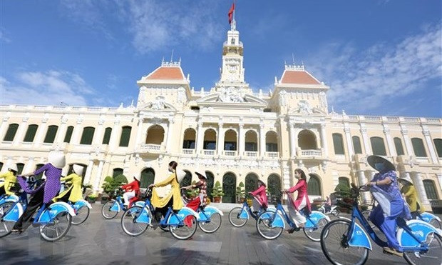 Delegates take part in the Ao Dai (long dress) parade, “I love Vietnamese Ao Dai”, by bicycle through the streets. (Photo: VNA)