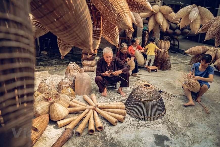 Strolling through the village, you will see elders sitting in front of their houses weaving fish pots and chatting. In the leisurely time following the harvest, they weave fish pots all day long. Before the harvest, though, they only weave at night. (Photo: Vietnam+)