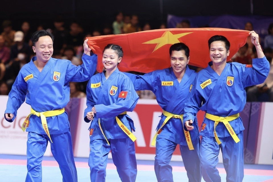 Lam Thi Thuy My, Le Toan Trung, Doan Hoang Tham, and Lam Tri Linh celebrate after winning the gold medal in the women’s Vovinam multi-weapon training event. (Photo: VNA)