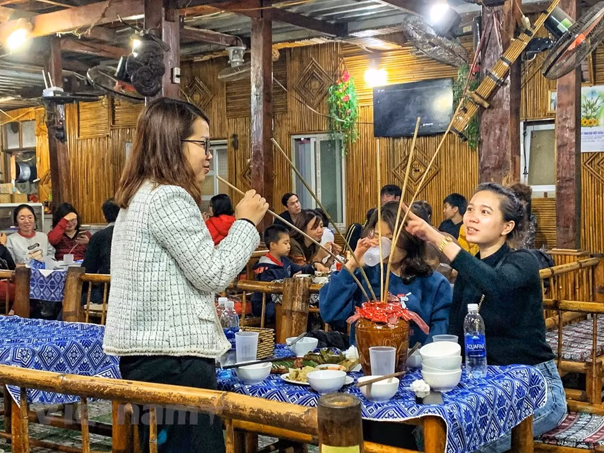 Many tourists said that they have closely followed COVID-19 developments every day in Vietnam and decided to go for a spring trip on these days as Vietnam has well controlled the disease’ spreading. In particular, visiting Lac village, tourists cannot miss the specialties of the land. Tourist will be invited to sit on the adorned mat in the center of the house. Then they will be invited to enjoy Can wine (a sort of popular wine in the upland and drunk out of a jar through pipes), com lam (a kind of delicious rice in the ethnic groups) with grilled meat and steamed freshwater fish. (Photo: Xuan Mai/Vietnam+) 
