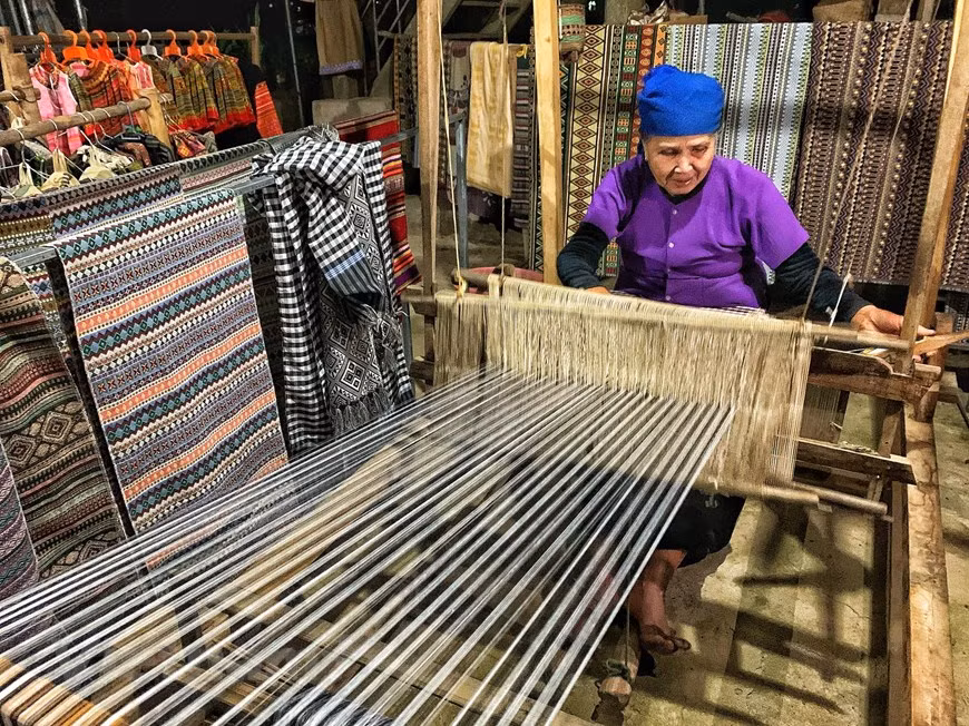 Brocade weaving is the traditional craft of the Thai that creates cultural characters that fascinate tourists going to Lac Hamlet. An unusual cultural feature of the Thai people is clearly seen through their costumes: a scarf that crosses the head, a blue shirt, and a black floor length skirt. Girls often wear a brocaded piece that crosses her chest that helps them look graceful. Tourists to Lac village of Mai Chau district, the northern province of Hoa Binh could watch local ethnic women weaving brocade products. Nothing is more exciting than wearing tradition clothes as a local and take some beautiful photos when coming there. (Photo: Xuan Mai/Vietnam+)