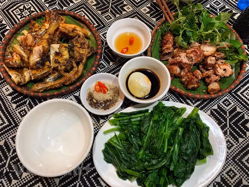 Grilled dishes in Lac village, Mai Chau district in Hoa Binh province are carefully seasoned with local herbs and spices, attracting tourists both at home and abroad. There are a lot of dishes in a daily meal of Thai ethnic people. And each dish has its own flavor. Thai ethnic people often roast cattle, poultry or seafood. And they often keep dried fish in their kitchens. When guests arrive at their houses, they roast dried fish again to serve guests. And then, they treat guests to other dishes. This shows the hospitality of Thai ethnic people. Thai ethnic people enjoy their dishes slowly to thoroughly feel their wonderful flavors. (Photo: Xuan Mai/Vietnam+) 