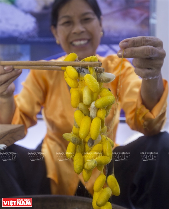 Cocoons are placed in boiling water to make the one long continuous thread separately (Photo:VNA)