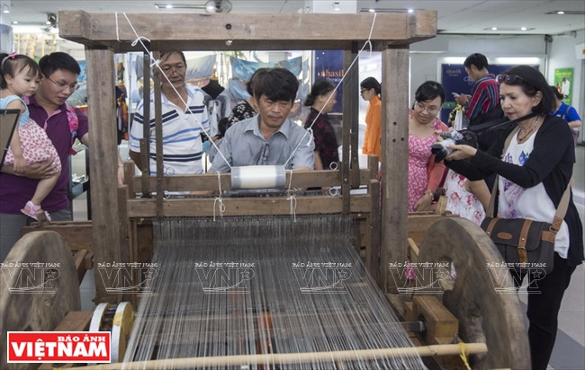 Artisan Tran Huu Phuong re-enacts a process to make silk fabric (Photo:VNA)