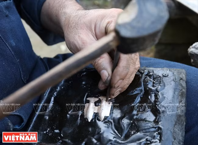 He uses pine resin for shaping (Photo: VNA)