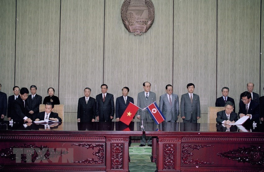 President Tran Duc Luong and President of the Presidium of the Supreme People's Assembly of the DPRK Kim Yong- nam witness the signing of a cooperation agreement between Vietnam and DPRK in Pyongyang, May 3, 2002 (Photo: VNA)