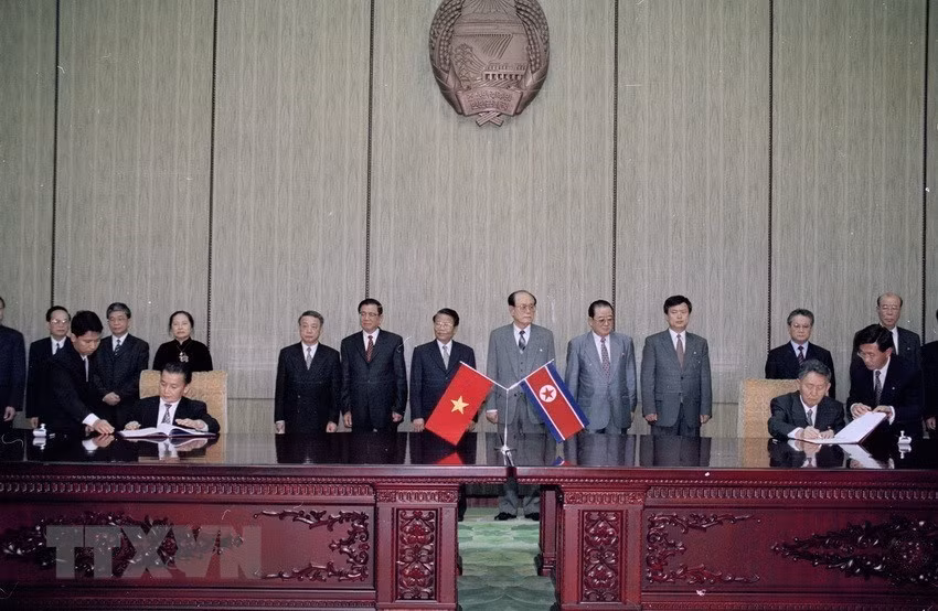 President Tran Duc Luong and President of the Presidium of the Supreme People's Assembly of the DPRK Kim Yong-nam witness the signing of a cooperation agreement between Vietnam and the DPRK in Pyongyang, May 3, 2002 (Photo: VNA)