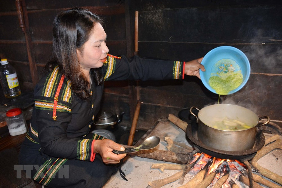 Before adding yao leaf powder, bones are stir-fried with other ingredients and then poured into water (Photo: VNA)