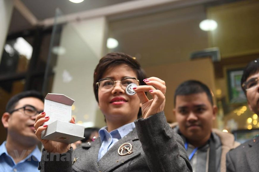 The commemorative coins are designed with two faces, one with the image of a dove - the symbol of peace, an olive branch and the flags of the DPRK and the US, and the other with the image of a lotus and the date of the summit (Photo: VNA)