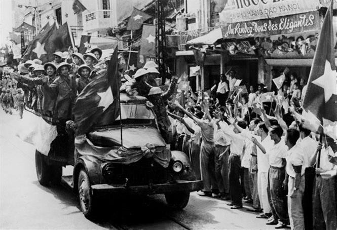 People raise flags and welcome troops marching to liberate the capital Hanoi, October 10, 1954. (Photo: VNA Archives)
