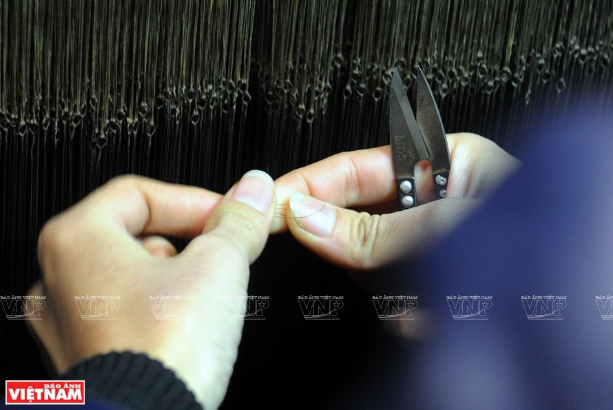 Joining fibers while weaving, a sophisticated technique. (Photo: VNA)
