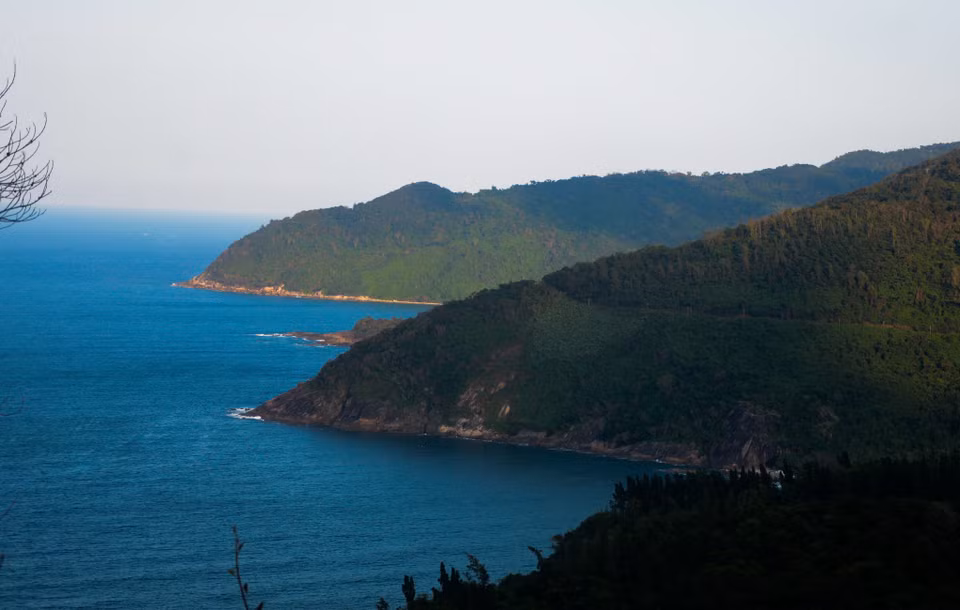The pass has lush jungle on one side and the sea on the other. (Photo: VNA)