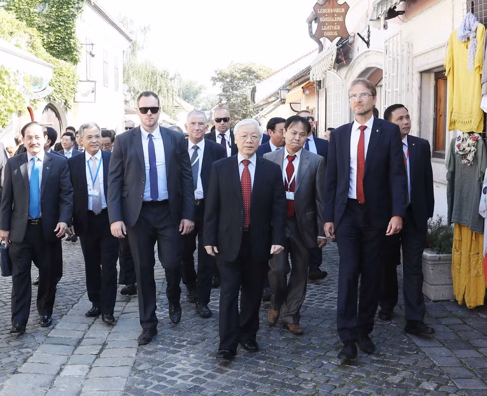Mayor Verseghi-Nagy Miklos guides General Secretary Nguyen Phu Trong and Vietnamese officials through the old streets of Szentendre town (Photo: VNA)