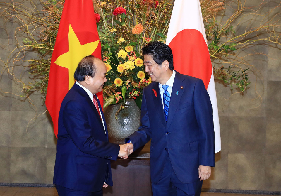Japanese Prime Minister Shinzo Abe (R) greets his Vietnamese counterpart Nguyen Xuan Phuc before the official welcome ceremony in Tokyo on October 8 morning (Photo: VNA)