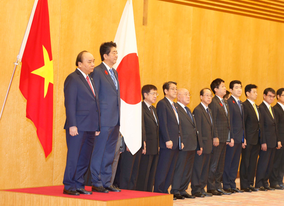 PMs Shinzo Abe and Nguyen Xuan Phuc listen to the countries' national anthems at the welcome ceremony in Tokyo on October 8 morning (Photo: VNA)