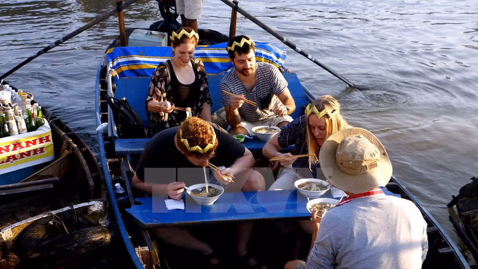 Foreigners have hu tieu - a popular breakfast dish at Cai Rang floating market (Photo: VNA)