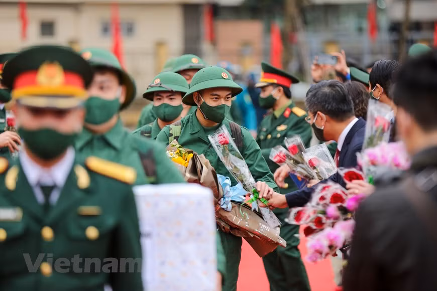 Young army conscripts receive flower bouquets from leaders of districts and Hanoi before leaving for their services. (Photo: Vietnam+)