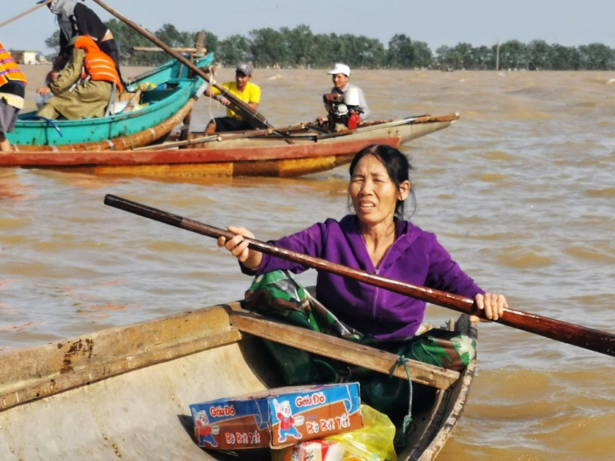 People row boats to receive relief supplies (Photo: VNA)