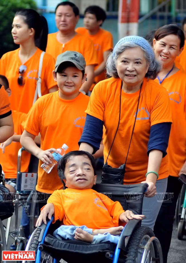 Tran To Nga walks with victims of Agent Orange in Ho Chi Minh City on the occasion of the 10th founding anniversary of the Vietnam Association of Victims of Agent Orange. (Source: VNA)
