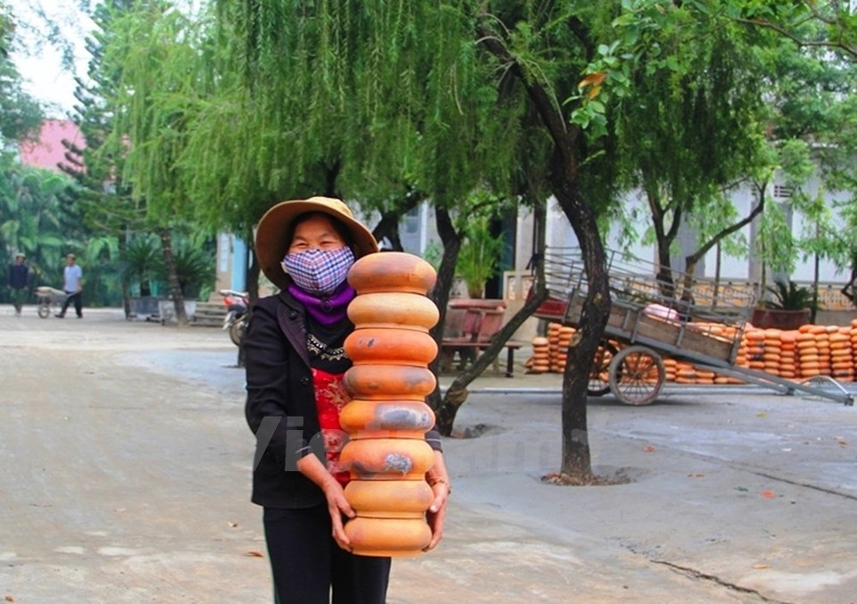 A local brings earthen pots for making the tree. (Source: VNA)