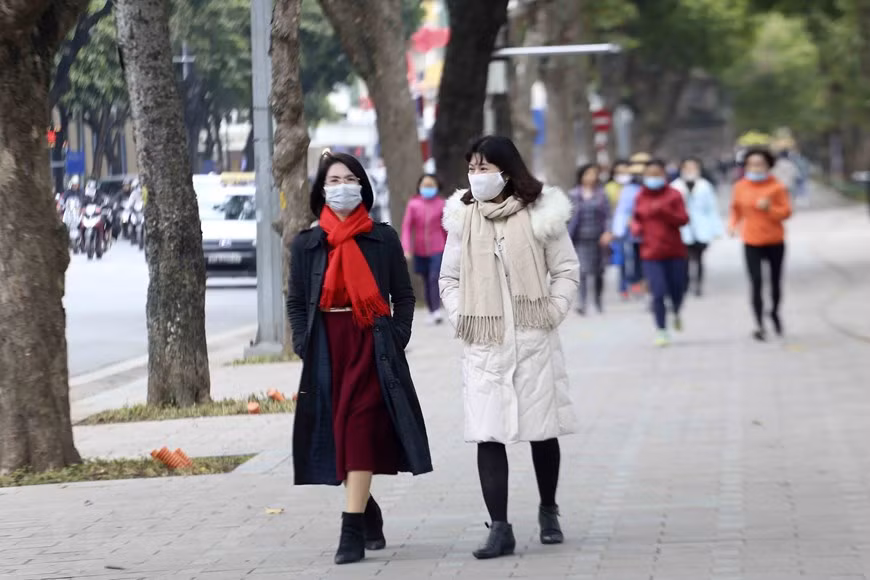 Pedestrians shiver though they have worn warm clothes (Photo: VNA)