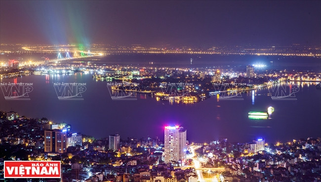 An overview of West Lake and Nhat Tan Bridge at night (Source: VNA)
