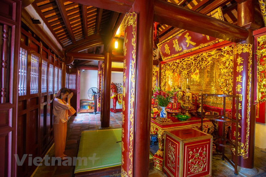 A woman offers prayers at Cua Ong Temple. Surrounded by several mountains, Cua Ong Temple was just a small shrine when it was first built over 700 years ago. It has been restored and expanded for many times in history and is now a large complex. While its exterior was constructed from various materials like stones, bricks from the renowned Bat Trang ceramic village in Hanoi, and baked clay, the interior was made from different types of wood like dinh (Erythrophloeum fordii Oliv), trac (Dalbergia cochinchinensis), and gu (Sindora tonkinensis). It is decorated with intricate carvings and red-lacquered and gold-inlaid boards engraved with characters of the old script (Photo: VietnamPlus)