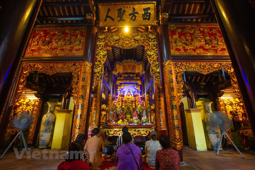 People offer prayers at a worshipping hall of Cua Ong Temple. The temple has been restored and expanded for many times in history and is now a large complex. Apart from Tran Quoc Tang, it also worships his father Tran Quoc Tuan and many other contributors to the triumphs over the Mongol invaders in the 13th century. Its interior was made from different types of wood like dinh (Erythrophloeum fordii Oliv), trac (Dalbergia cochinchinensis), and gu (Sindora tonkinensis). It is decorated with fine carvings and red-lacquered and gold-inlaid boards engraved with the old script’s characters. There are 34 intricately carved statues of all sizes with high artistic values in the temple at present (Photo: VietnamPlus)