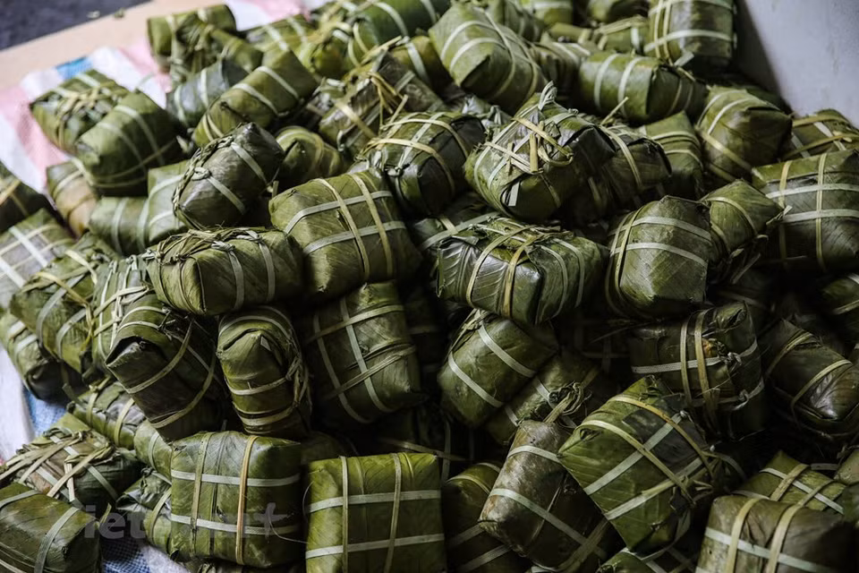 The Tet tray of Vietnamese people cannot be complete without green Chung cake. Chung cake is a traditional Vietnamese cake which is made from glutinous rice, mung bean, pork and other ingredients. Its origin is told by the legend of Lang Lieu, a prince of the sixth Hung King, who became Hung King 's successor thank to his creation of Chung cake and Giay cake, which symbolise the Earth and the Sky respectively. People in Tranh Khuc village said that making Chung cake is not difficult, but each stage must be meticulous and thorough. In order to have good cakes, they have to carefully choose rice, bean, pork, and leaves. (Photo: Minh Son/Vietnam+)