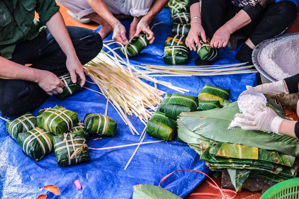 Chung cake is a traditional Vietnamese cake which is made from glutinous rice, mung bean, pork and other ingredients. Its origin is told by the legend of Lang Lieu, a prince of the sixth Hung King, who became Hung King 's successor thank to his creation of Chung cake and Giay cake, which symbolise the Earth and the Sky respectively. Dong leaves and giang strings have to be washed carefully in order to preserve the taste of the cake. Giang strings may be soaked in salt water or steamed so that they can become flexible enough for wrapping. Pork side is preferred for Chung cake because its fatty flavour associates well with the glutinous rice and bean, developing a special taste. (Photo: Minh Son/Vietnam+)