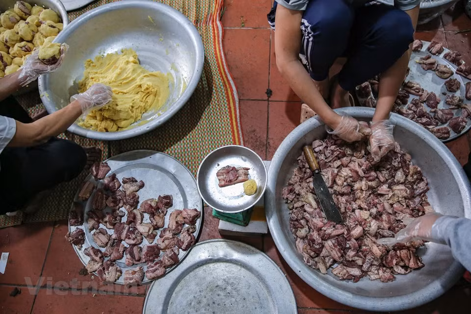 Mis Sau's family in Tranh Khuc village has been involved in making Chung cakes for decades. Ms. Sau said she usually packs 200-300 cakes on normal days. But from early December, the time when the Lunar New Yerar comes near, the number of cakes that she wraps is 2-3 times higher than usual. In order to make a good Chung cake, Ngan said she has to buy and select high quality ingredients. For example, dong leaves (a kind of leaves used to wrap Chung cake) should be bought from provinces of Thanh Hoa, Nghe An, Yen Bai, Lao Cai or Ha Giang because they are soft, hard to be broken and have a nice green colour after cooking. (Photo: Minh Son/Vietnam+)