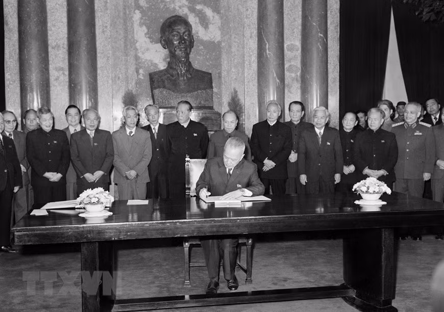 Acting President Nguyen Huu Tho signs an order to announce the new Constitution, December 1980. (Photo: VNA)