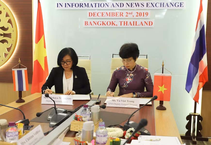 VNA Deputy General Director Vu Viet Trang and her PRD counterpart Pichaya Muangnao ink a document approving a cooperation report (Photo: VNA)