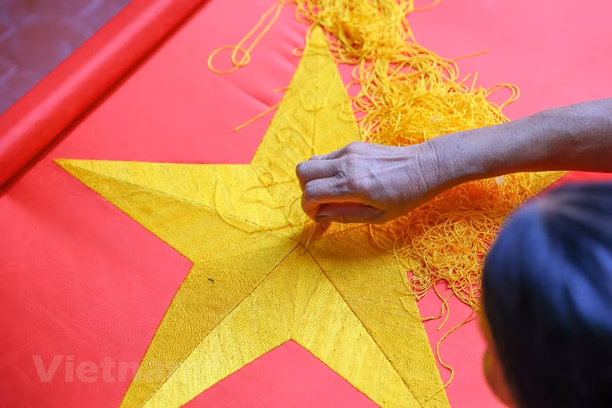 To make a beautifully embroidered flag, several time-consuming and painstaking steps ought to be done. Those include choosing fabrics, measuring fabrics, cutting fabrics, and embroidering the five pointed golden star, among others. Each of them requires a lot of efforts and meticulousness from the makers. For a veteran embroiderer, it often takes between 3 and 5 days to complete an embroidered flag. For amateurs, it might take up to a week. Embroidering the five-pointed golden star in the middle of the flag is the hardest as it’s not easy to make the wings symmetrical. As a result, each embroidered flags is sold at at least 300,000 VND (12.94 USD). (Photo: VietnamPlus)